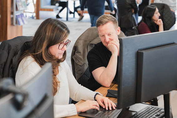 Two colleagues sat at a desk working together