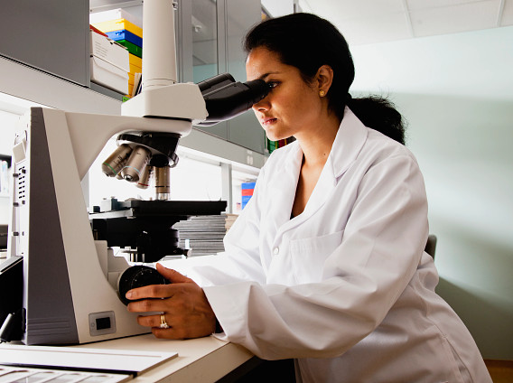 Scientist looking through microscope